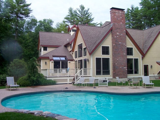 Pool with home in background showing the pool area before Dex by Terra conducted a pool renovation project.