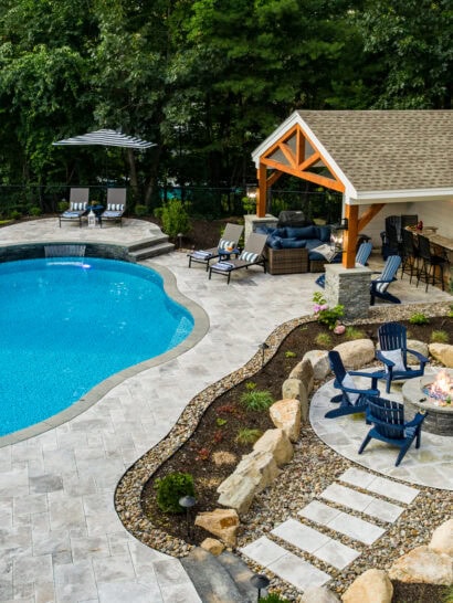 Drone shot of a new Dex By Terra pool deck, patio and fire pit in Whittinsville MA.