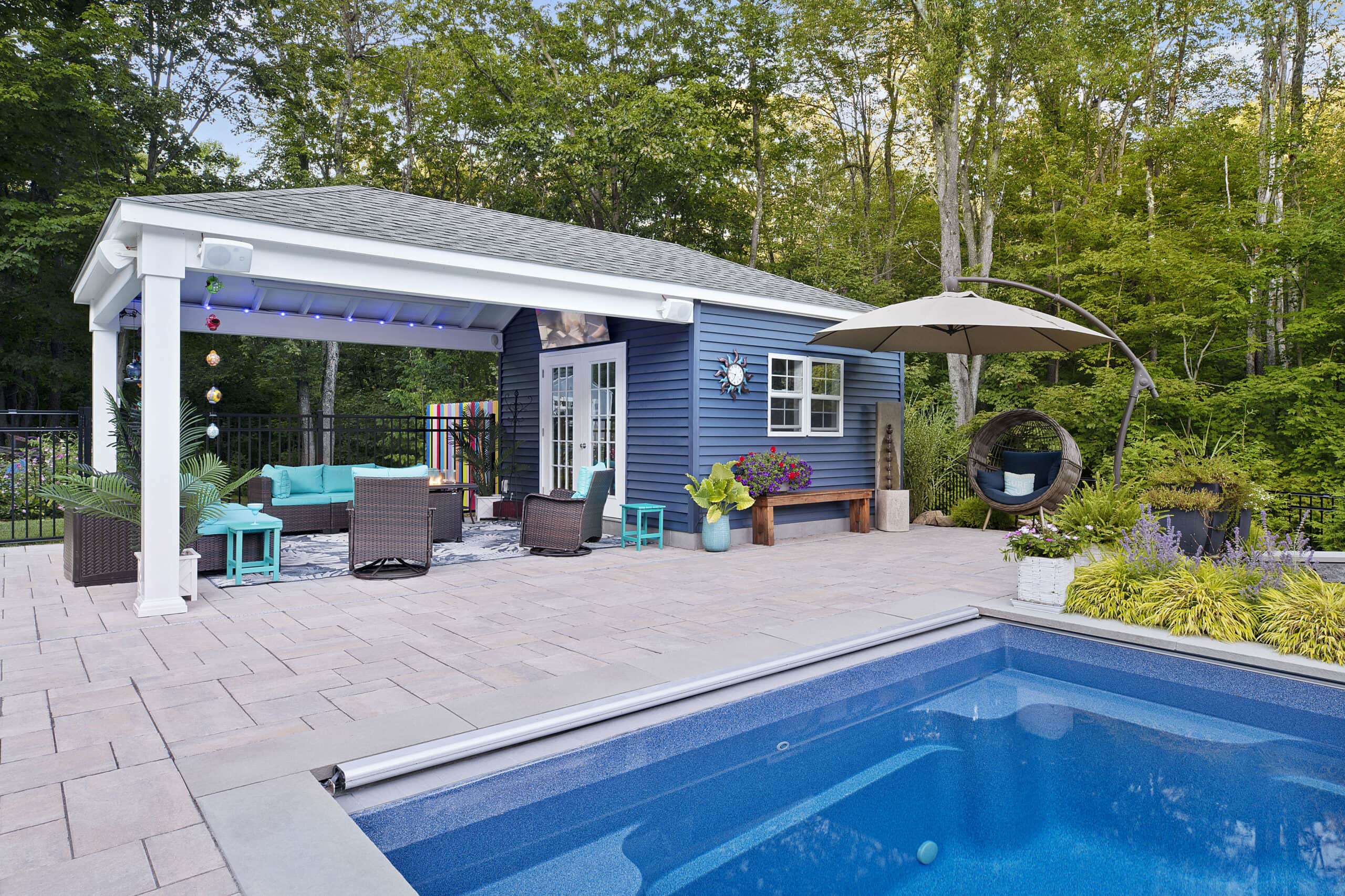 The pool house and pavilion with fire pit and seating. Dex by Terra landscape and hardscape project in Westminster, MA.