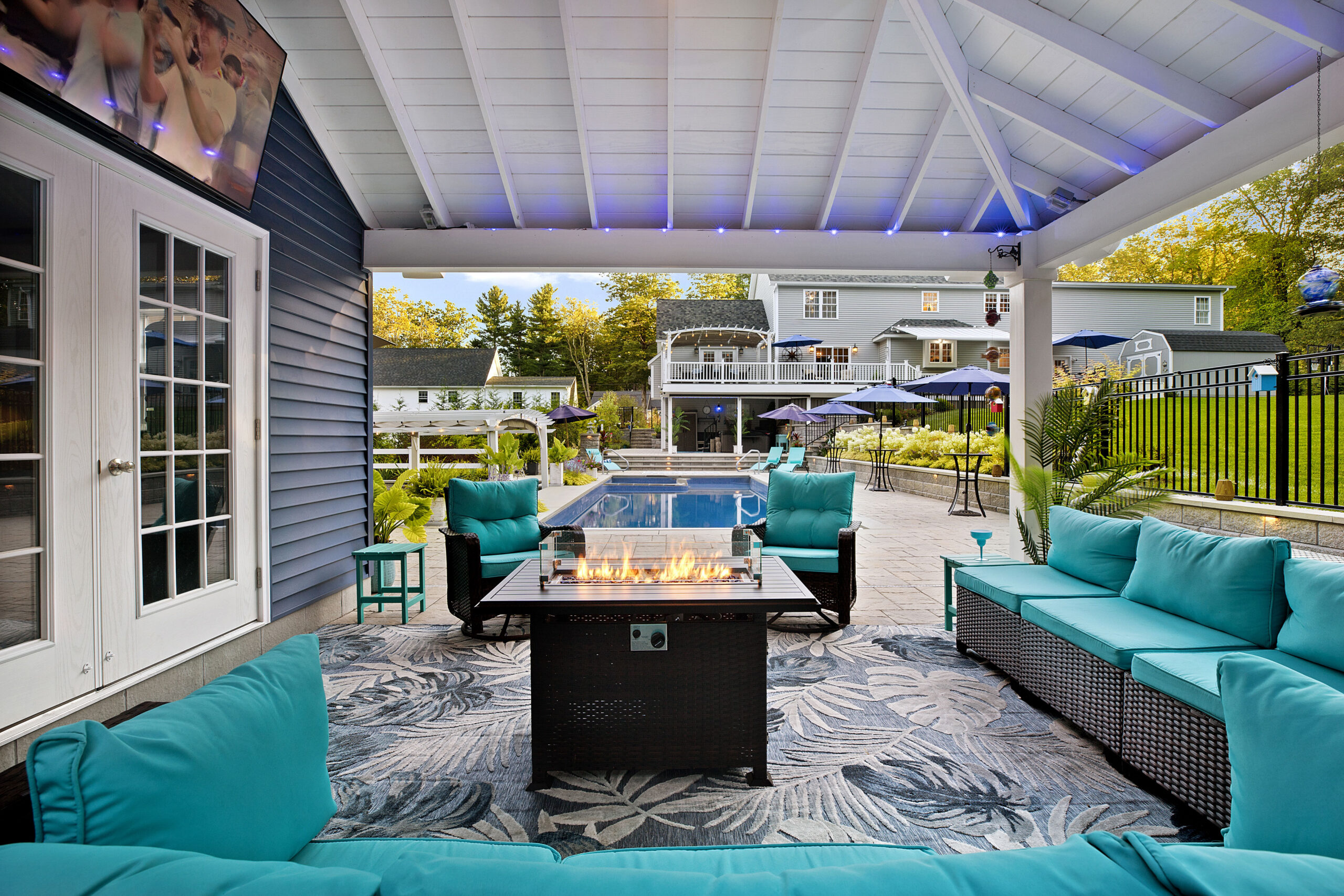 The pool house pavilion provides shelter for a gas fire pit and provides a view of the backyard toward the home. Dex by Terra landscape and hardscape project in Westminster, MA.