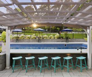 The poolside bar with sun setting in background. Dex by Terra landscape and hardscape project in Westminster, MA.