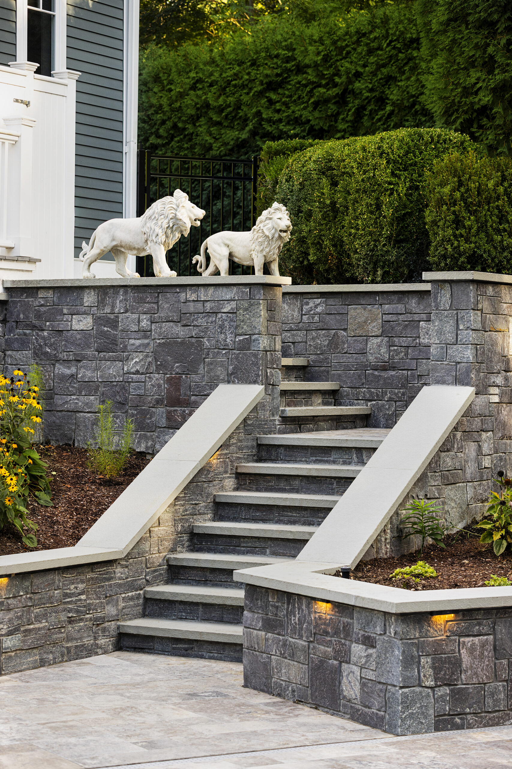 Lion statues overlook the stone stairs. Dex by Terra hardscape project in Lincoln, MA.