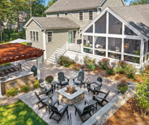 Drone view of Backyard in Dunstable, MA with fire pit patio, outdoor kitchen, pergola, screened-in porch.