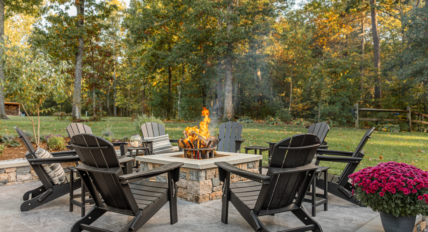Wood burning fire pit with chairs on a patio.