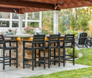 high top chairs by the built-in bar under the pergola. Landscape design in Dunstable, MA built by Dex by Terra.