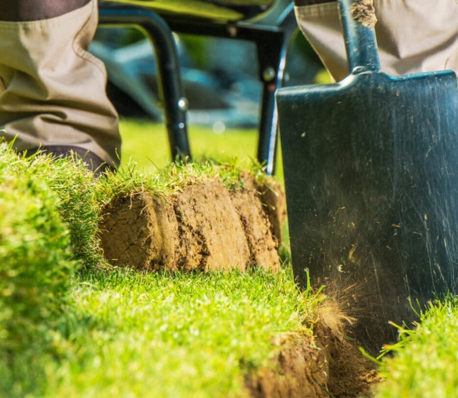 Dex by Terra worker digging trench for irrigation or landscape lighting installation.