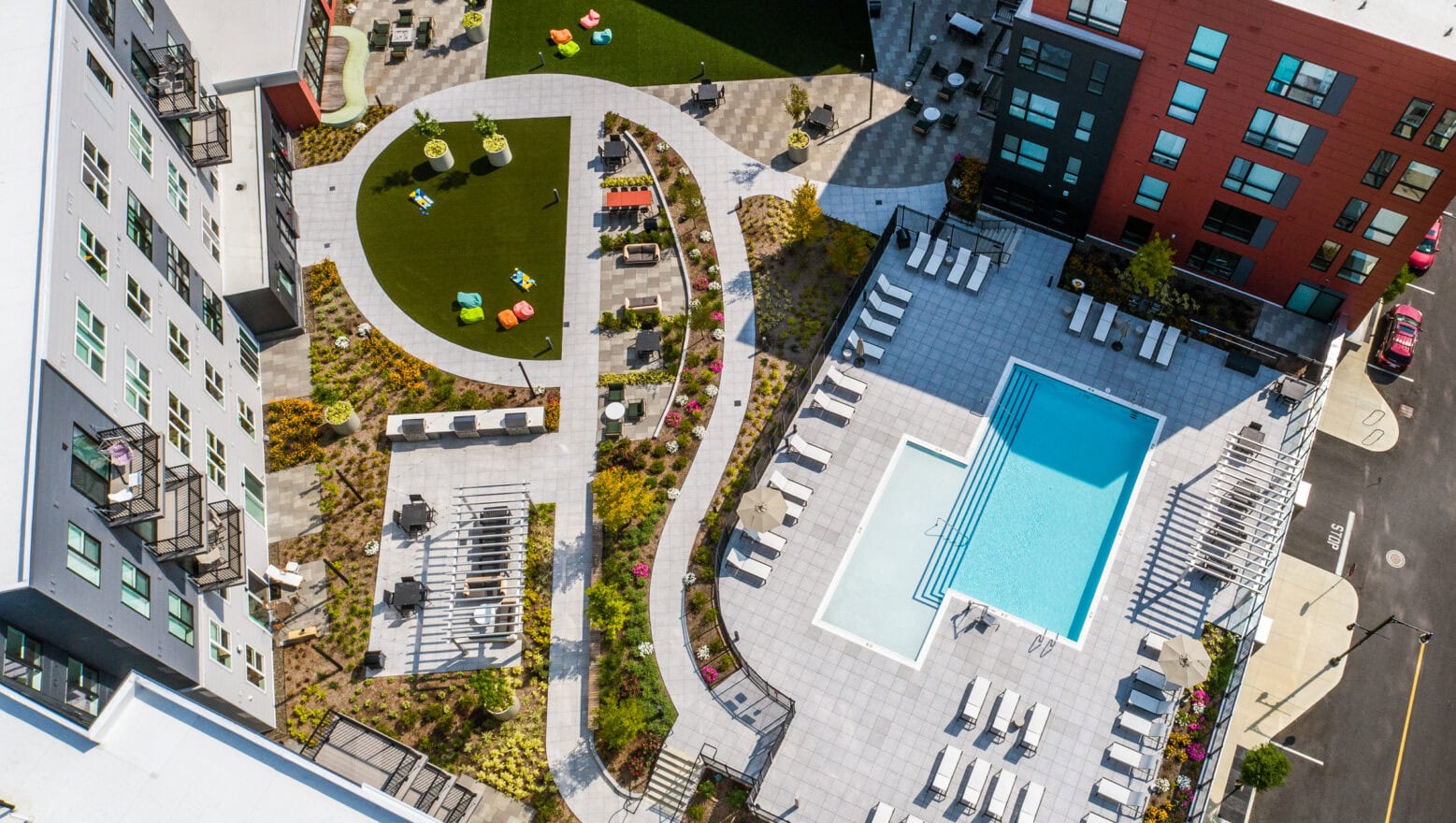 Podium-level Courtyard with pool, and patios at The Revington in Worcester, MA. Hardscape & Landscape by Dex by Terra.