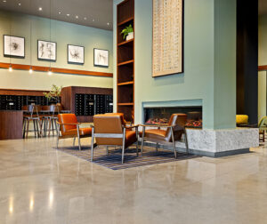 A gas fireplace surrounded by chairs in the main lobby area of 75 Canal Apartments in Manchester, NH.