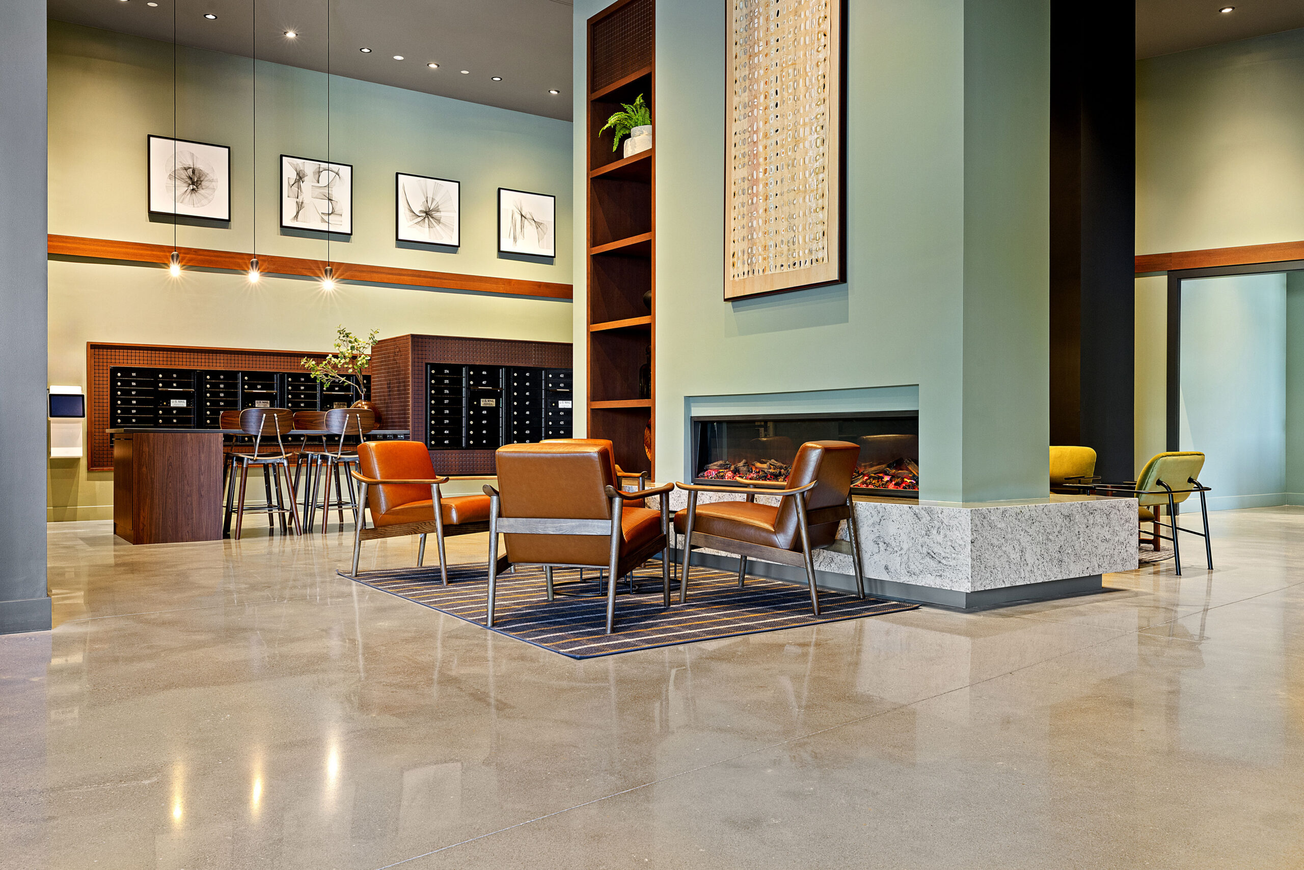 A gas fireplace surrounded by chairs in the main lobby area of 75 Canal Apartments in Manchester, NH.