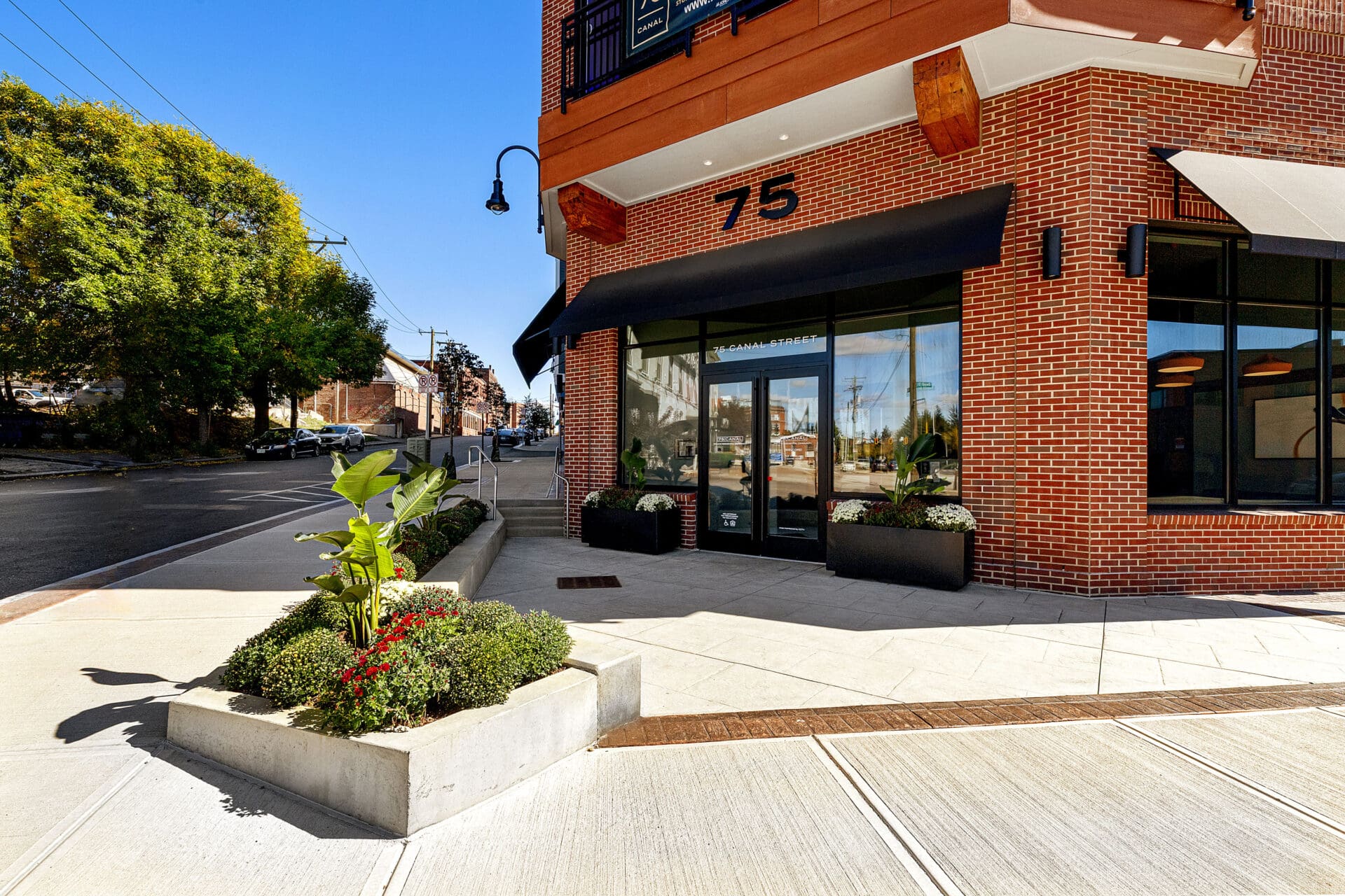 The brick main entrance and front sidewalk of 75 Canal Street Apartments in Manchester New Hampshire.