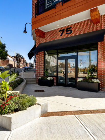 The brick main entrance and front sidewalk of 75 Canal Street Apartments in Manchester New Hampshire.