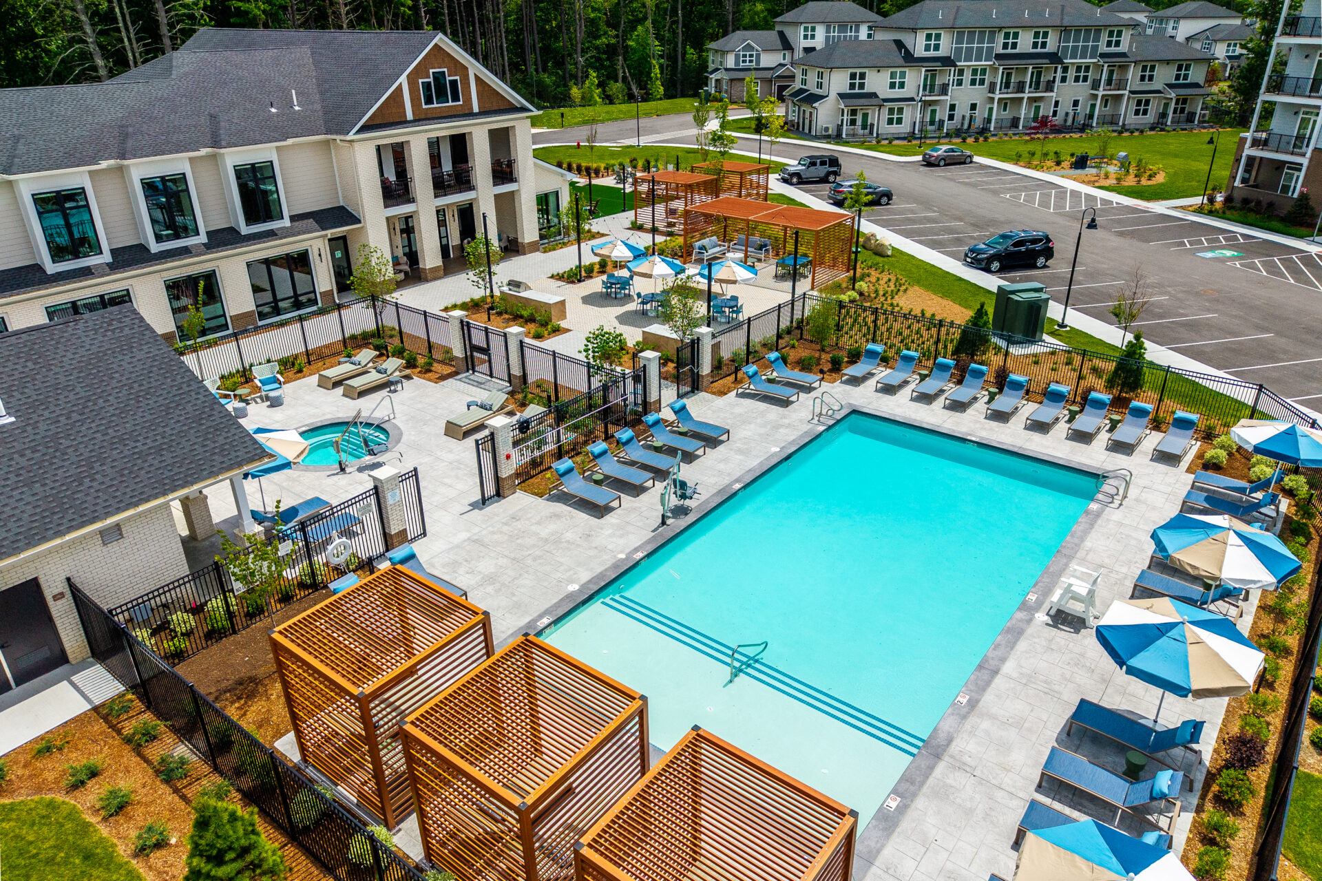 Drone view of the amenity areas with pool, pergolas, spa, and grill zone. The Penstone Apartments in Walpole, MA. Hardscaping and landscaping by Dex by Terra of Hudson, MA.
