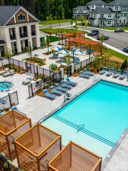 Drone view of the amenity areas with pool, pergolas, spa, and grill zone. The Penstone Apartments in Walpole, MA. Hardscaping and landscaping by Dex by Terra of Hudson, MA.